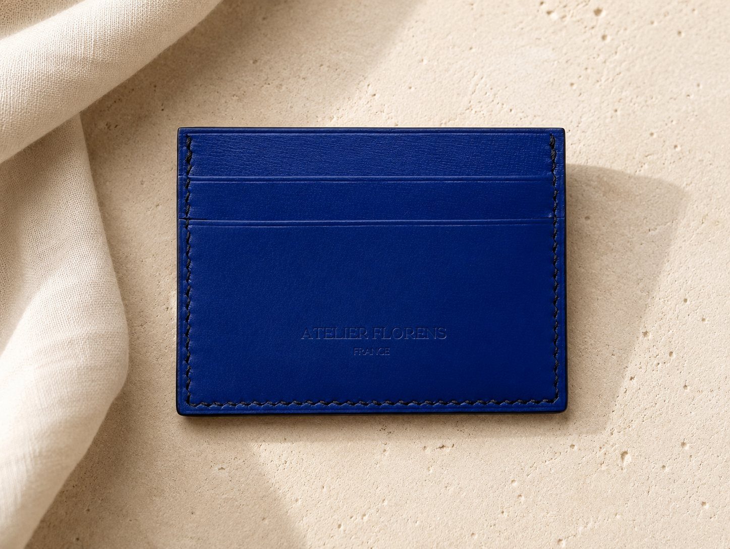 Détail de la texture et des coutures du collection l'île — porte-cartes en cuir bleu roi