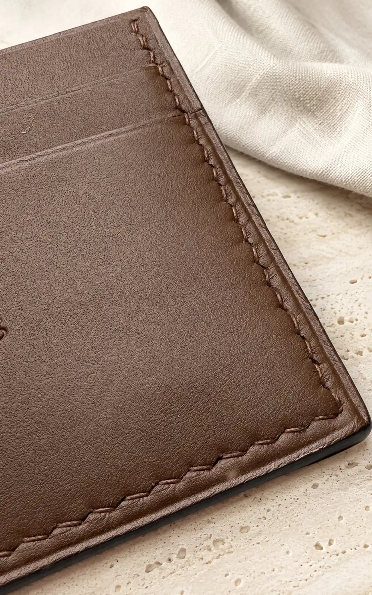 Détail de la texture et des coutures du collection l'île — porte-cartes en cuir cognac