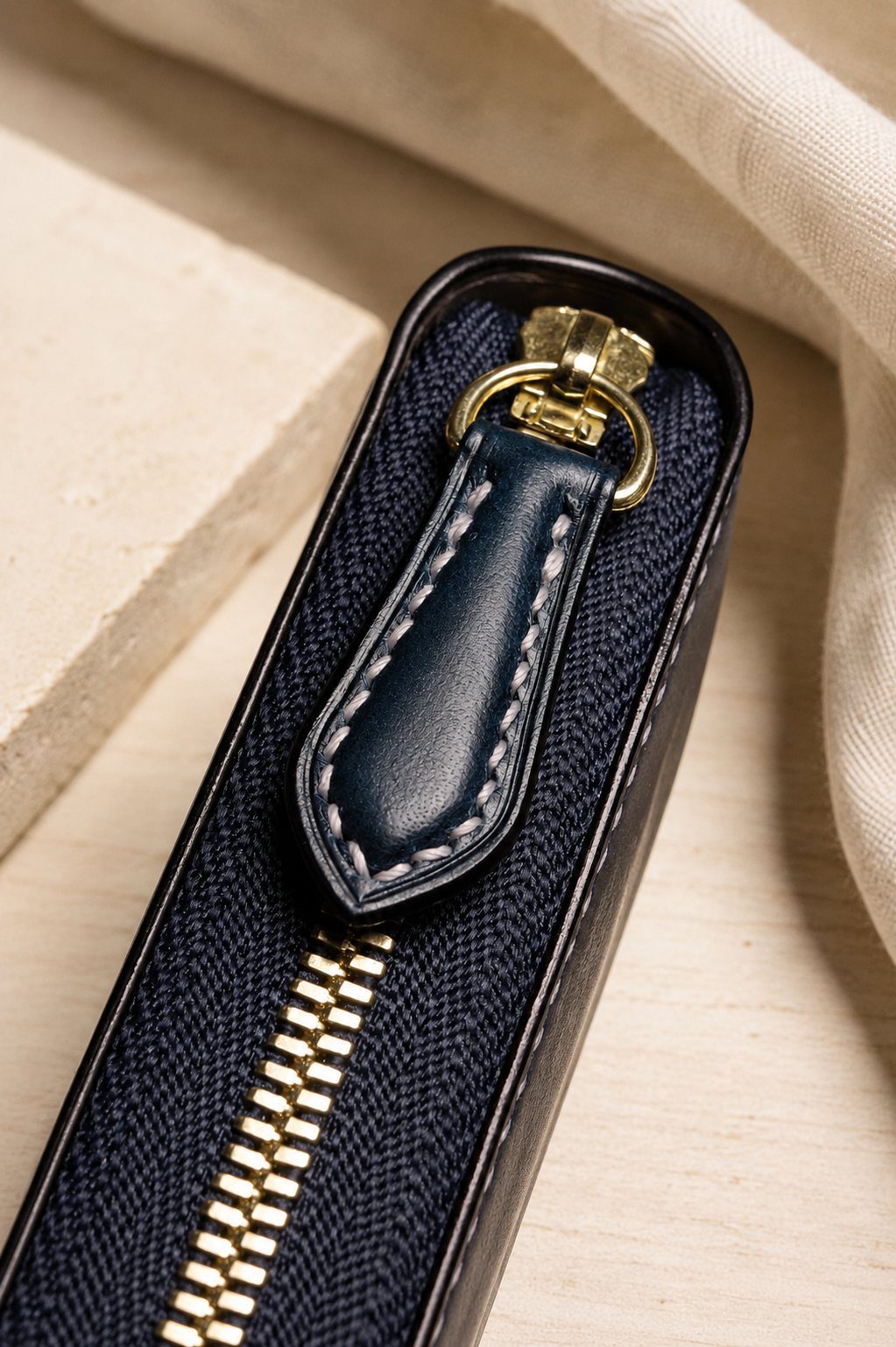 Détail de la texture et des coutures du portefeuille léman en cuir bleu marine