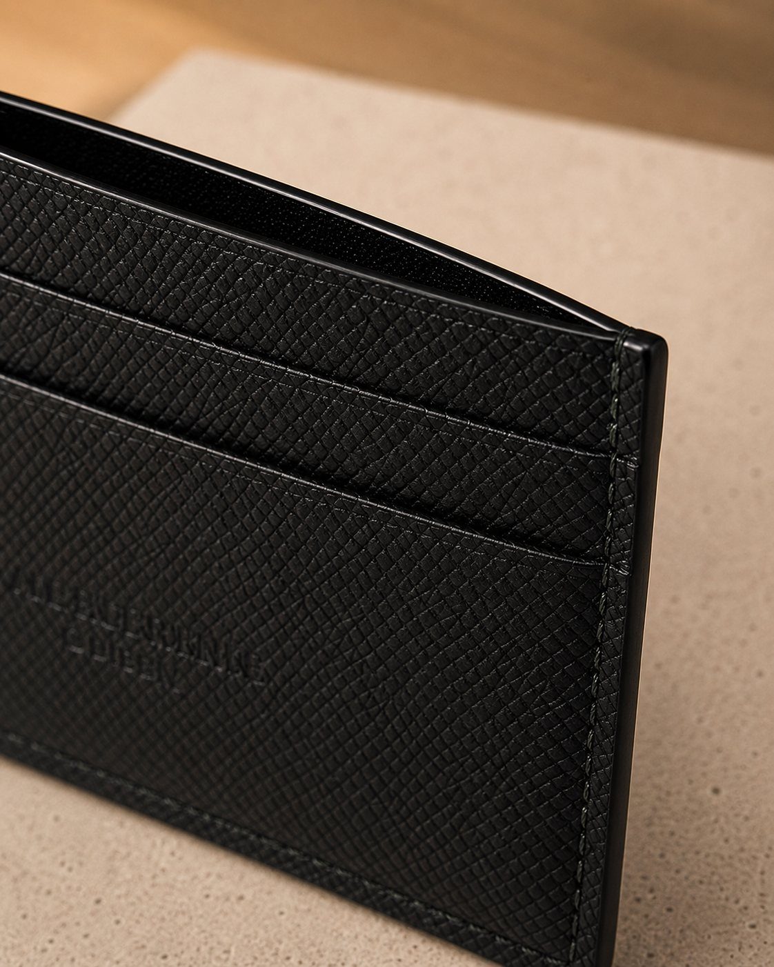 Détail de la texture et des coutures du porte-cartes rive classique en cuir noir