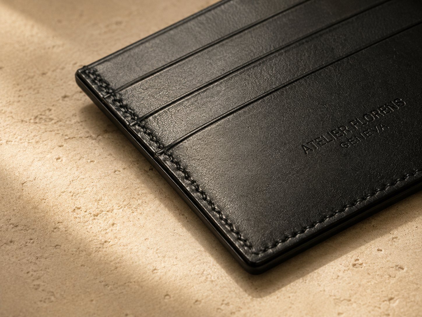 Détail de la texture et des coutures du porte-cartes rive grand modèle en cuir noir